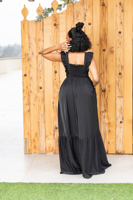Woman wearing a black dress with a wooden fence background