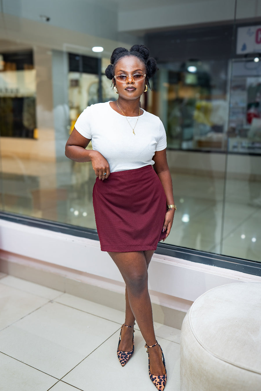 Woman in a white top and red skort standing in a shopping mall.